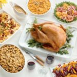 A bountiful Thanksgiving dinner table laden with a roasted turkey, side dishes, and autumnal decorations, representing the traditional Thanksgiving feast celebrated in the United States.