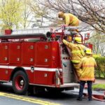 A bright red fire truck illustrates the point that while traditionally associated with emergencies, red is less visible than yellow, especially at dawn or dusk, making yellow a safer choice for school buses.