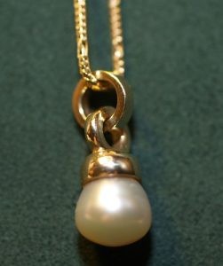 A lustrous pearl, formed naturally within a clam, showcasing its iridescent beauty.