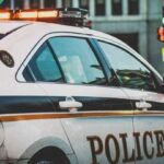 A police car on patrol in a city street, highlighting law enforcement presence.