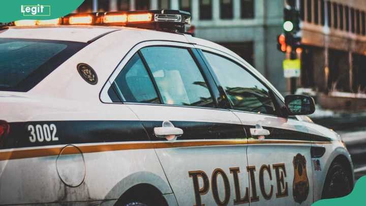 A police car on patrol in a city street, highlighting law enforcement presence.