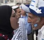 A pro-Palestinian woman wearing a headscarf shouts at a pro-Israeli man wearing a blue and white hat bearing the Israeli flag