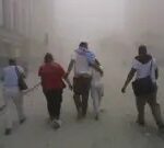 Civilians flee as a tower of the World Trade Center collapses September 11, 2001