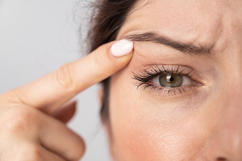 Close-up of a woman's eye twitching, emphasizing the involuntary muscle spasm