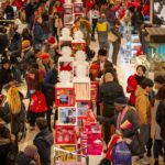 Crowds of shoppers fill the streets of New York City for Black Friday sales, highlighting the shopping frenzy associated with the day.