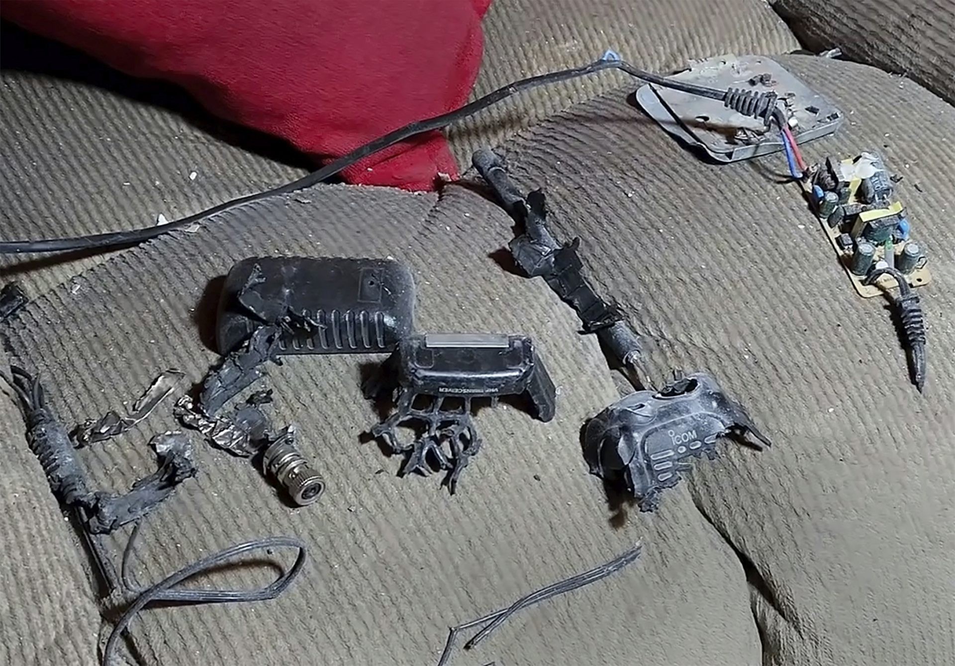 Debris of exploded walkie-talkies used by Hezbollah, showcasing the aftermath of targeted attacks on their low-tech communication devices.