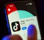 Getty Images A mobile phone user clicks to download the TikTok app