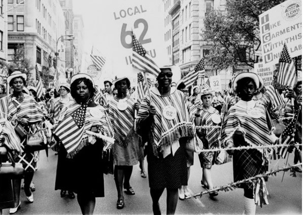 ILGWU Local 62 marches in a Labor Day parade. Source: https://www.flickr.com/photos/kheelcenter/5278801929/in/photolist-7iEKir-93teUn-93wkss-93v4aV-93wxPL-21eteK3-93wxK1-93wkjy-93tf1z-93wiWj-93wiSJ-93teFx-93wUPj-93teXv-93wYkh