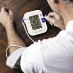 Man monitoring blood pressure at home, focusing on diastolic reading for heart health