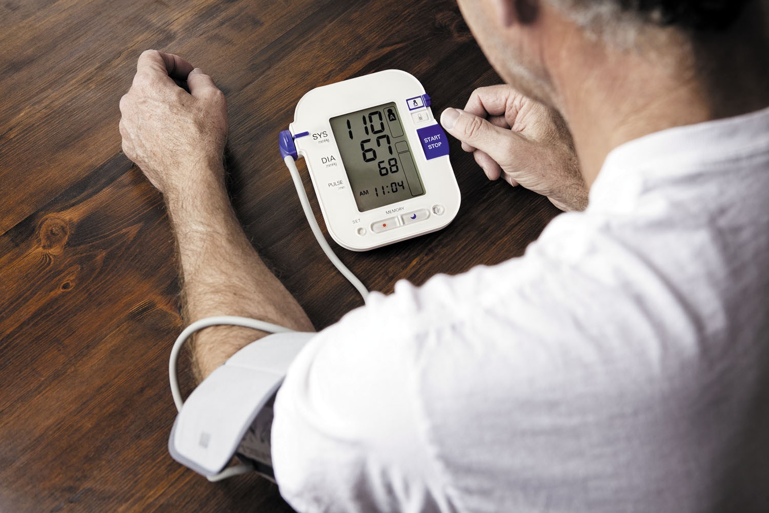 Man using a home blood pressure monitor to check diastolic pressure