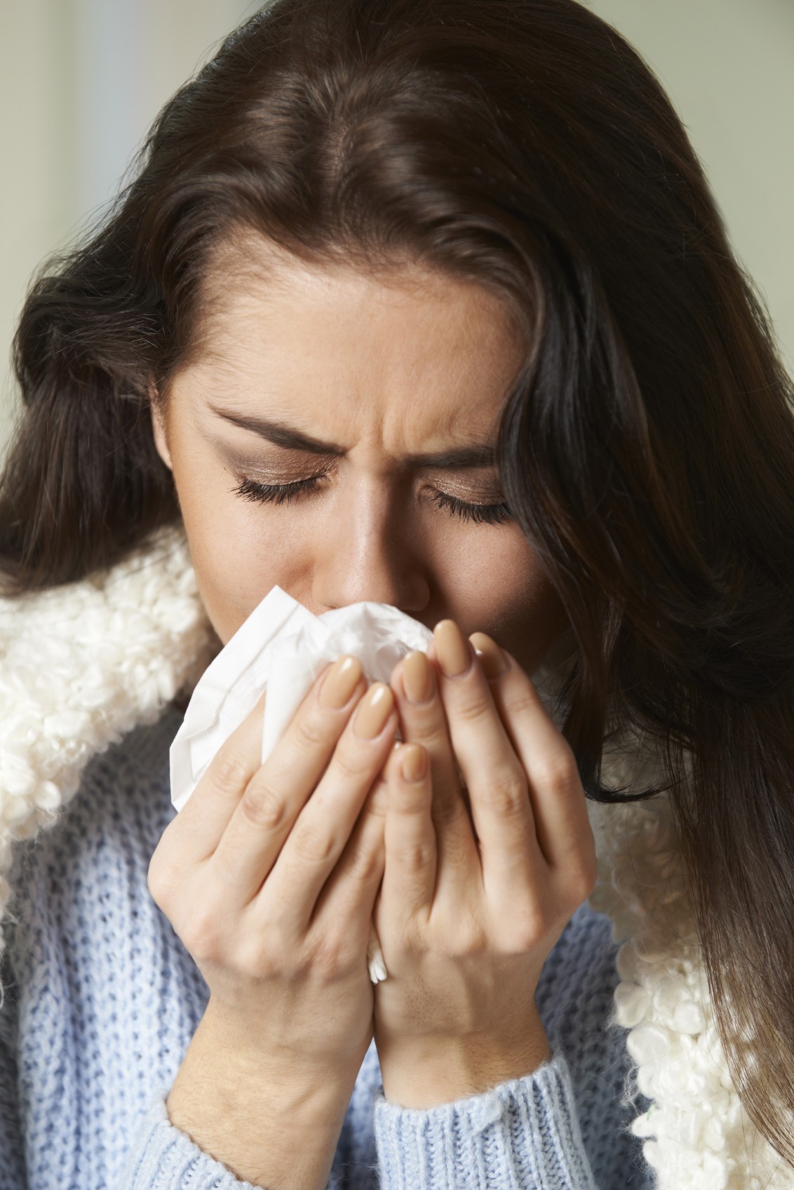 Person blowing nose with tissue