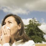 Person sneezing in bright sunlight.