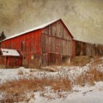 Red barn in a snowy landscape, showcasing its vibrant color against the white snow