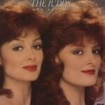 The Judds Why Not Me album cover featuring Naomi and Wynonna Judd smiling and posing with guitars