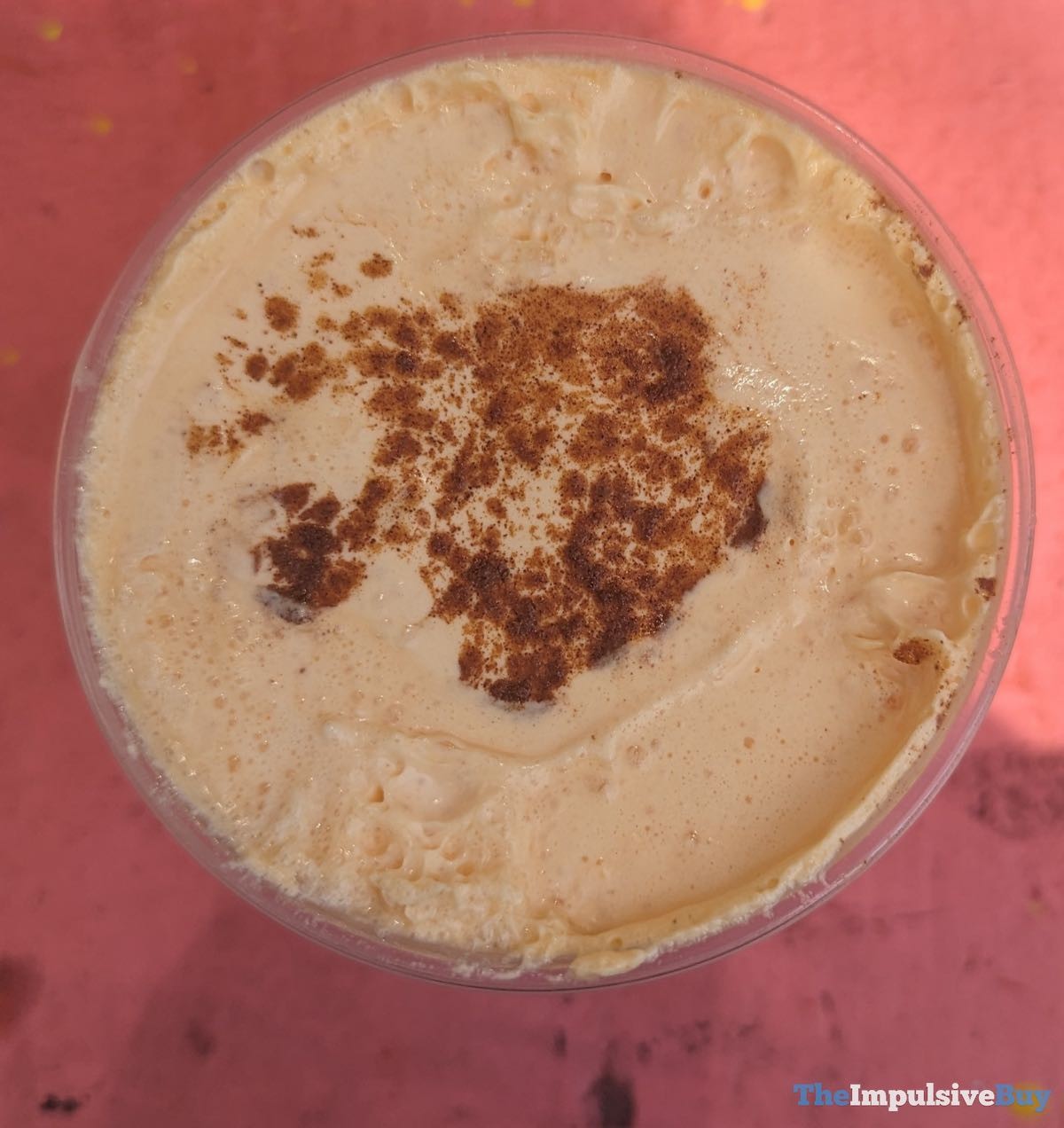 A close-up of a Pumpkin Chai Latte with foam and spice topping