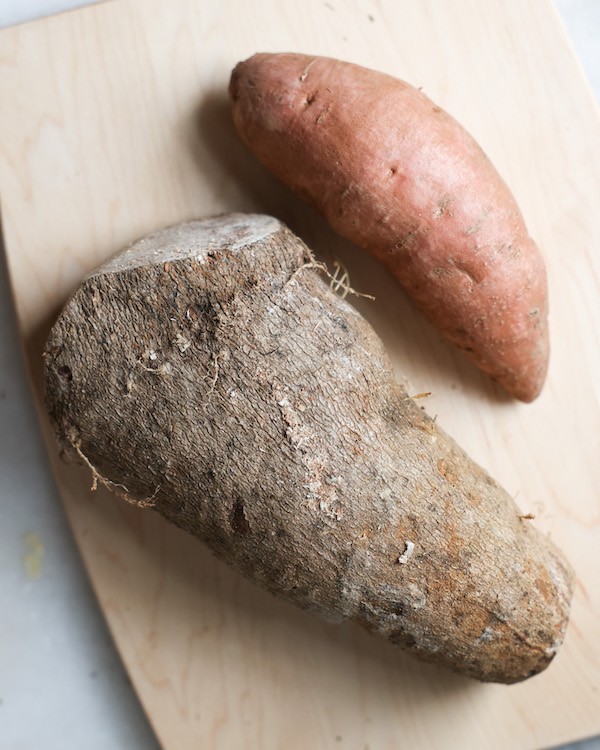 A vibrant display of various sweet potatoes, showcasing their different shapes, sizes, and colors